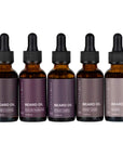 Scentral Zone 1oz assorted beard oils in amber colored dropper bottles with scents: amber & smoke, mulled mandarin, forest creek, sweet cigar, naked. These products are placed with a white background. 