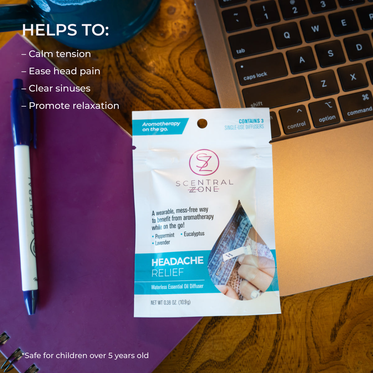 Scentral Zone headache relief clip-on aromatherapy diffuser pouch in a white and teal design laid on top of a laptop and next to a notebook. Text is displayed on the top of the graphic explaining this product helps calm tension, ease head pain, clear sinuses, etc. 
